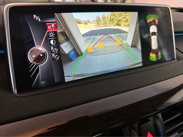 Car backup camera with green guide lines aligned to a garage seam
