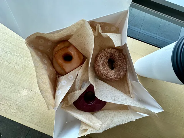Coffee and donut on a desk, soft morning light